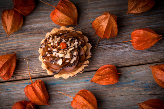 cake and phisalis on rustic wooden background