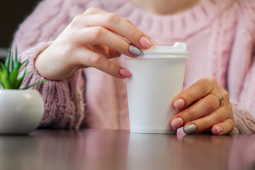 female hands holding a cup of coffee