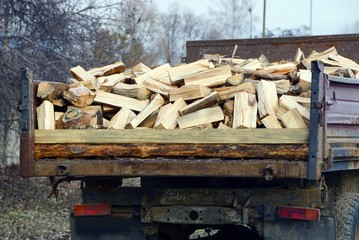 a pile of wooden firewood and logs in an iron truck