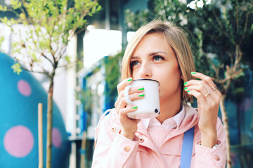 Young woman sitting at the street cafe , drinking coffee