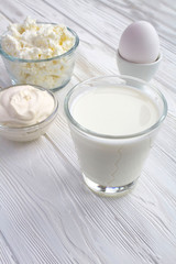 Homemade farm dairy products on the white wooden background. Location vertical. Copy space.