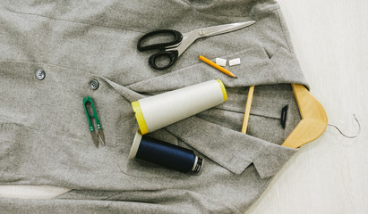 Top view. Jacket, scissors, a pencil, spools,chalk, scissors for yarn, a hanger.