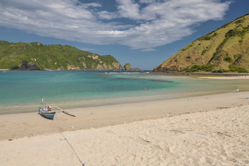 Boats on sand beach in bright sunlight