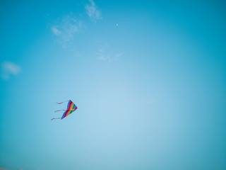 Colorful kite flying in the wind blue sky.
