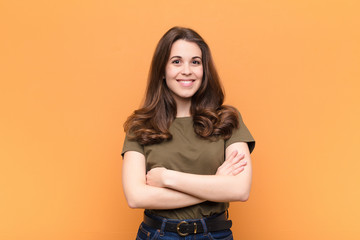 young pretty woman smiling to camera with crossed arms and a happy, confident, satisfied...