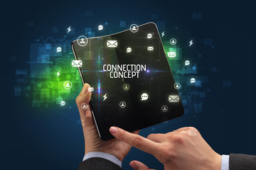Businessman holding a foldable smartphone with CONNECTION CONCEPT inscription, social networking concept