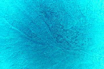 Fototapeta na wymiar The texture of the frost on the glass is painted in turquoise color.