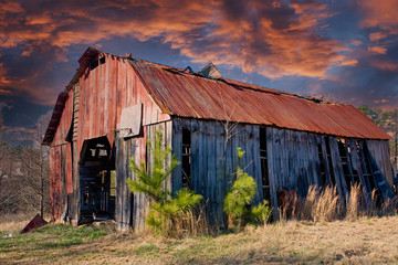 An old barn with a rusty roof in a rural area