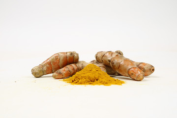 Turmeric powder and turmeric root extract on a white background are used as a tonic for the body and food ingredients.