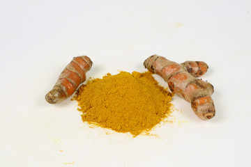 Turmeric powder and turmeric root extract on a white background are used as a tonic for the body and food ingredients.