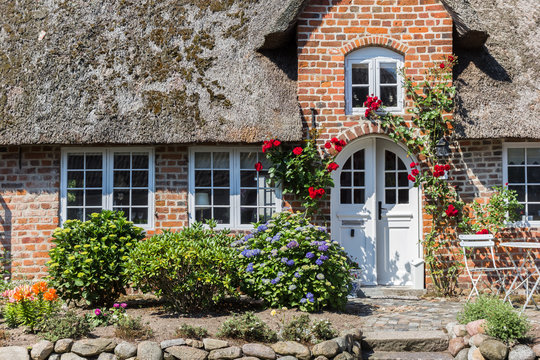 Front of a traditional house with red roses in Mogeltonder, Denmark