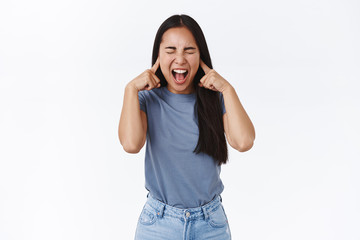 Distressed and fed up asian teenage girl with long dark hair, screaming losing temper, cant control...