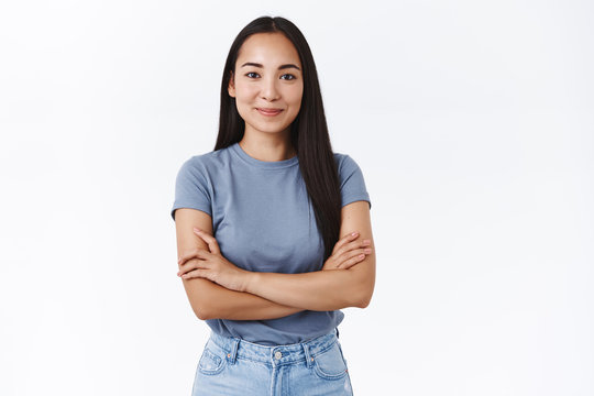 Young confident and determined asian girl start her first day work, assertive everything go well, cross hands chest in self-assured pose, smiling pleased, stand white background