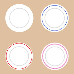 Set of white plates with various decorative elements. Light brown background.