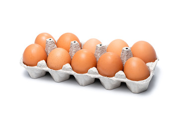 ten brown chicken eggs in a cardboard tray on a white background