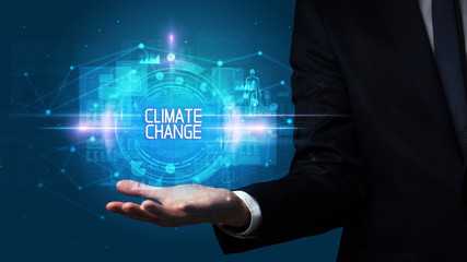 Man hand holding CLIMATE CHANGE inscription, technology concept