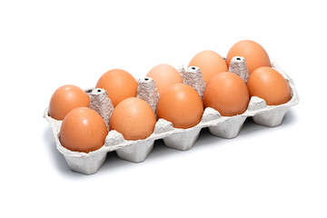 ten brown chicken eggs in a cardboard tray on a white background