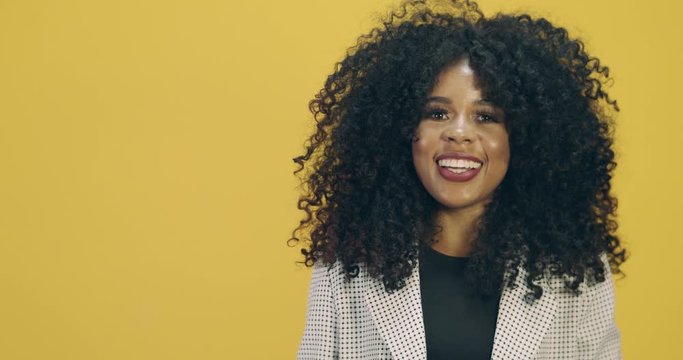 Beauty of african american woman with afro hairstyle and glamour makeup. Brazilian woman. Mixed race. Curly hair. Hair style. Yellow background.