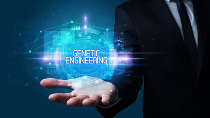 Man hand holding GENETIC ENGINEERING inscription, technology concept