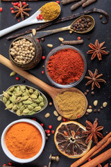 Spices and herbs flat lay, black color background, top view.
