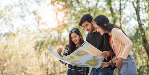 Multi-Ethnic Travelers looking at the map on travel vacations with natural background. Diversity, Friendship, People. copy space