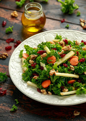 Kale salad with dried cranberry, carrots, walnuts and apple. healthy vegan food.