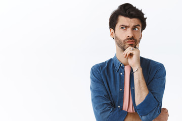 Thoughtful, serious-looking handsome bearded guy, look away pouting pensive, touching chin, thinking, making choice or imaging plan, standing white background pondering how solve situation - obrazy, fototapety, plakaty
