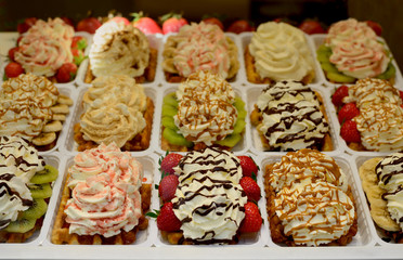 Beautiful and Colorful Belgian Waffles in Brussels topped with strawberries, bananas, kiwi, chocolates and whipped cream.