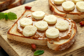 Fototapeta na wymiar Peanut Butter and banana Sandwich on wooden board. morning breakfast