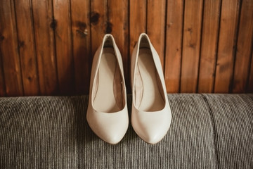 Bride shoes with wooden wall behind. Wedding accessories fashion background. Rustic wedding backdrop.