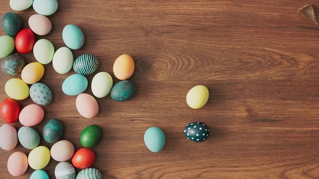 Hands Taking colorful Easter eggs of wooden table. Easter holiday decorations, Easter concept background.