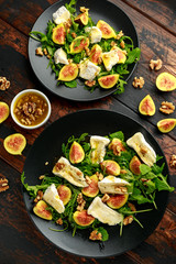 Vegetarian camembert cheese, fig and Arugula, hot rocket salad served on black plate