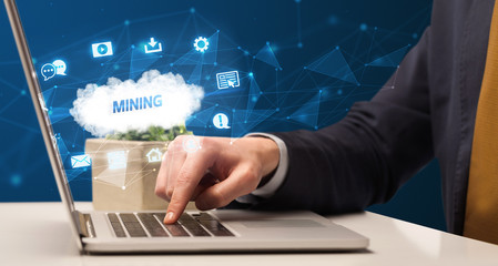 Businessman working on laptop with MINING inscription, modern technology concept