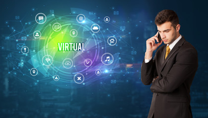 Businessman thinking in front of technology related icons and VIRTUAL inscription, modern technology concept