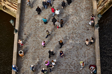 People walk across the Charles Bridge in Prague, top view