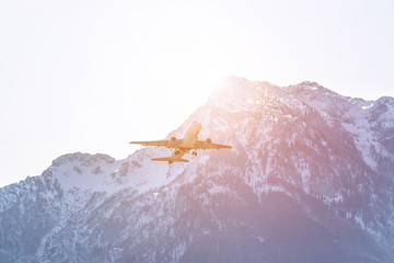 Airplane scenery:  take off from airport, mountain range in the alps. Travel by air, transportation