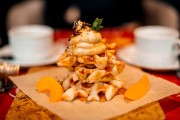 Belgian waffles for breakfast. Waffles with whipped cream, caramel sauce and fresh fruit