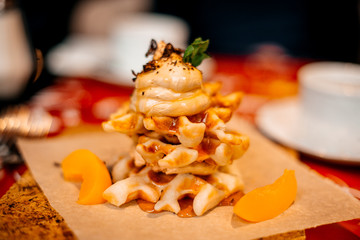 Belgian waffles for breakfast. Waffles with whipped cream, caramel sauce and fresh fruit