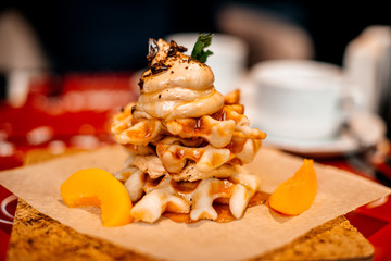 Belgian waffles for breakfast. Waffles with whipped cream, caramel sauce and fresh fruit