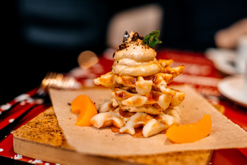 Belgian waffles for breakfast. Waffles with whipped cream, caramel sauce and fresh fruit