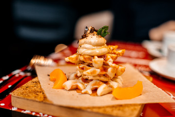 Belgian waffles for breakfast. Waffles with whipped cream, caramel sauce and fresh fruit