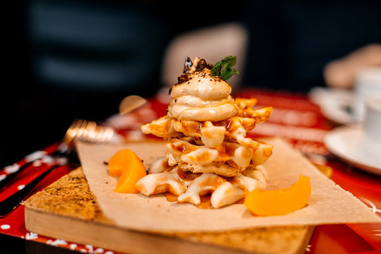 Belgian waffles for breakfast. Waffles with whipped cream, caramel sauce and fresh fruit