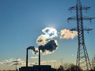 Smoke from industrial chimneys against a blue sky. Smoke from factory chimneys in an urban...