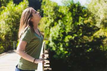 Side shot of woman breathing fresh air in nature