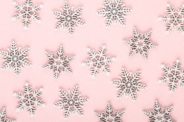 Christmas background. White snow decorations on a pink background.