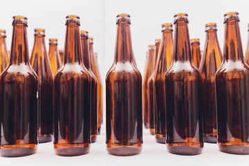 Close-up of beer bottles, focus on middle one, isolated on white background.