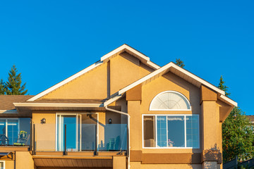 A perfect neighborhood. Houses in suburb at Summer in the north America. Top of a luxury house with nice window over blue and white sky.