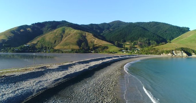 4k hovering aerial motion of the natural boulder barrier causeway beside the sea connecting Pepin island with south island at the picturesque area known as Cable Bay,Rotokura,South Island New Zealand