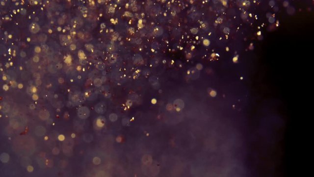 Abstract golden particles with blurred defocused bokeh moves chaos, snow flakes