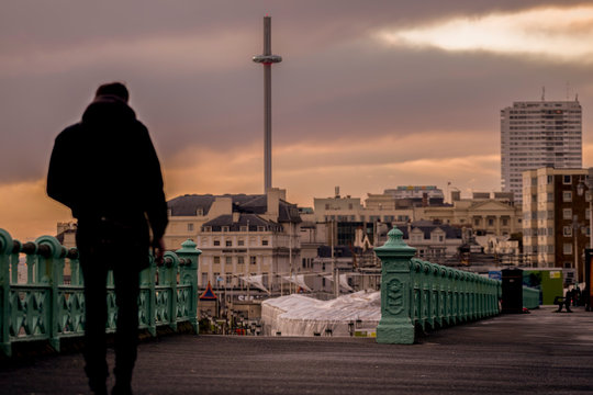 man walking along Brighton sea front